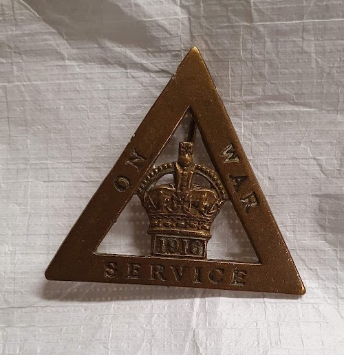 An 'On War Service' badge